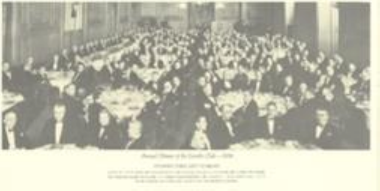 Historic black and white photo of a large group of seated men in formal attire.